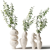 Branches with leaves in wavy clay vases