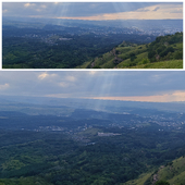 Panoramic view of green hills, forest and city in the distance